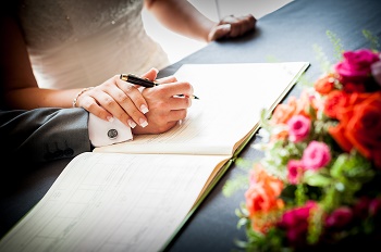 a picture of a two people signing the registrar